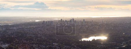 Photo for Homes and Buildings in a modern city. Aerial Panorama. Sunset Sky. Burnaby, Vancouver, BC, Canada. - Royalty Free Image