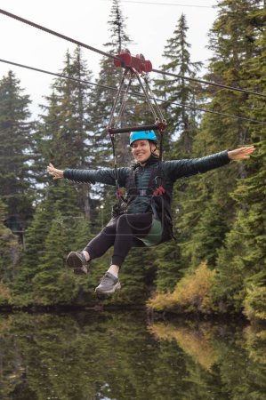 Foto de Mujer Aventura montando en una Zipline. Actividad de diversión extrema. - Imagen libre de derechos