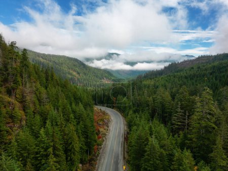Photo for Scenic Highway by Trees with Mountains in Background. Colorful Cloudy Sky. Vancouver Island, British Columbia, Canada. - Royalty Free Image