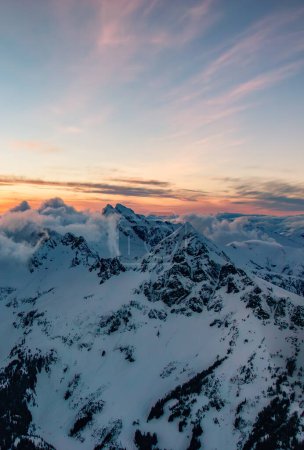 Foto de Pico de montaña cubierto de nieve. Canadian Nature Aerial Background (en inglés). Columbia Británica, Canadá. Cielo del atardecer - Imagen libre de derechos