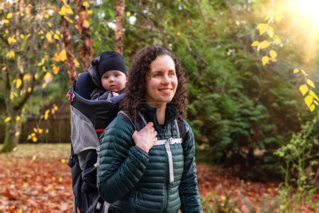 Photo for Mother walking in Suburban Neighborhood with Baby in Carrier. Fall Season. Burnaby, Vancouver, BC Canada. - Royalty Free Image