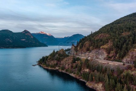 Téléchargez les photos : Sea to Sky Highway at Pacific Ocean Coast with Canadian Mountain Landscape. Nuageux lever de soleil. Howe Sound près de Vancouver et Squamish, BC, Canada. - en image libre de droit