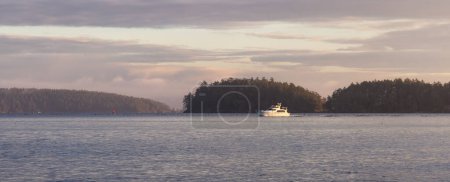 Boat by Gulf Islands on the West Coast of Pacific Ocean. Canadian Nature Landscape Background. Winter Sunrise. Victoria, Vancouver Island, BC, Canada.