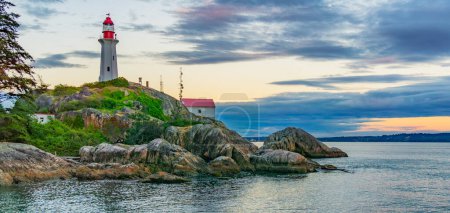 Téléchargez les photos : Phare sur une côte rocheuse pendant un coucher de soleil nuageux. Horseshoe Bay, West Vancouver, Colombie-Britannique, Canada. - en image libre de droit