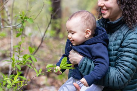 Caucasian Baby Boy and Mother in Forest playing with branches and trees. British Columbia, Canada.