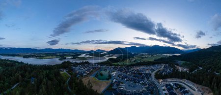 Aerial panorama of homes in town. Canadian Mountain Landscape. Sunny Sunset. Fraser Valley, BC, Canada.