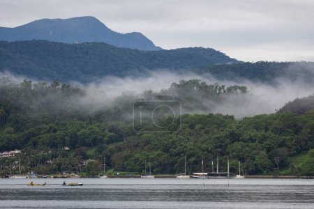 Foto de Beautiful view to foggy weather clouds over green rainforest mountains on ocean town, Paraty, Rio de Janeiro, Brazil - Imagen libre de derechos