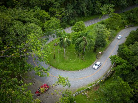Photo for Beautiful aerial view to sharp turn on road in green rainforest mountains, Guaraqueaba area, Paran, Brazil. - Royalty Free Image