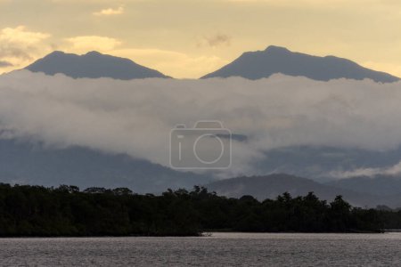 Foto de Hermosa vista de la bahía del océano a las nubes lluviosas sobre las verdes montañas de la selva tropical en Guaraqueaba, Paran, Brasil. - Imagen libre de derechos