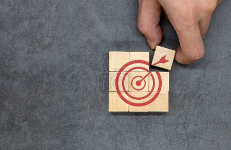 Téléchargez les photos : A dart target aiming icon on a wooden cube. Business objectives and concepts of success. Focus on your goals and achieve successful business. - en image libre de droit