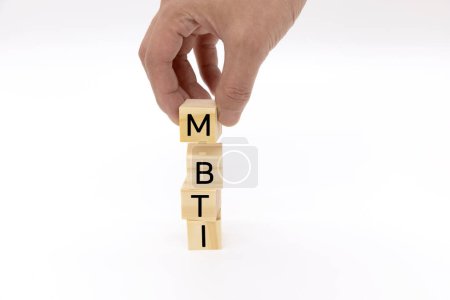 Four wooden blocks with the letter MBTI, Myers-Briggs Type Indicators