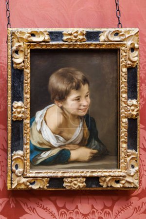 Foto de Londres, Reino Unido - mayo de 2023: Pintura de Bartolomé Esteban Murillo titulada A Peasant Boy Leaning on a Sill. Representa a un campesino apoyado en un bloque de piedra astillada que le hace sonreír - Imagen libre de derechos