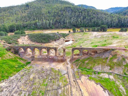Aerial drone view of pylons of an old railway bridge that crossed the Odiel river to release ore from the nearby Santa Rosa mine in the hiking route of the water mills of Sotiel Coronada