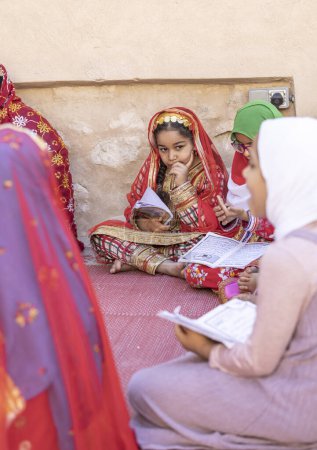 Foto de Nizwa, Oman, 2nd December 2022: omani girls reciting a Holy Book - Imagen libre de derechos