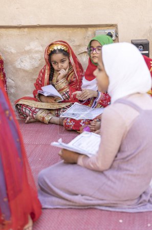 Foto de Nizwa, Omán, 2 de diciembre de 2022: niñas omani recitando un Libro Sagrado - Imagen libre de derechos