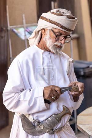 Téléchargez les photos : Nizwa, Oman, 2 décembre 2022 : homme omani en tenue traditionnelle au marché des armes - en image libre de droit