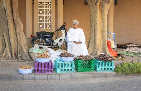 Foto de Nizwa, Oman, 2nd December 2022: Omani man selling vegetables at a market - Imagen libre de derechos