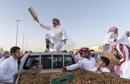 Foto de Buraydah, Arabia Saudita, 4 de agosto de 2023: hombre saudí recogiendo fechas de camiones - Imagen libre de derechos
