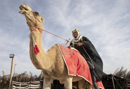 Foto de Hombre beduino montando su camello - Imagen libre de derechos