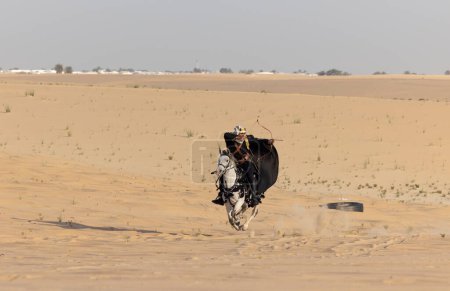 Téléchargez les photos : Homme en costume traditionnel avec son cheval dans un désert - en image libre de droit