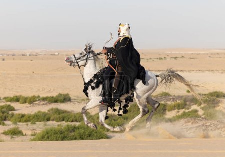 Foto de Hombre con ropa tradicional con su caballo en un desierto - Imagen libre de derechos