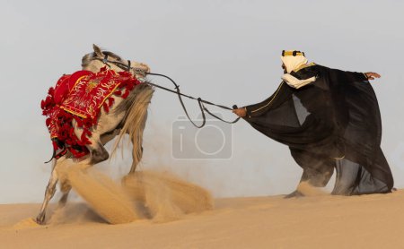 Foto de Hombre saudí vestido con su semental blanco - Imagen libre de derechos