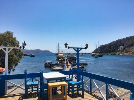 Photo for Datca,Mugla,Turkey - August 18 2018 View of Excursion boats anchored in the ancient Knidos Harbor from Knidos Restaurant in the big port of Datca and tourists enjoying their holida - Royalty Free Image
