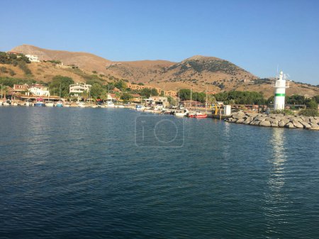 Foto de Vista de la ciudad y el faro desde el mar de Gokceada Imbros isla kalekoy puerto. Kalekoy vista del puerto desde el mar de la isla de Imbros en Canakkale Turquía - Imagen libre de derechos