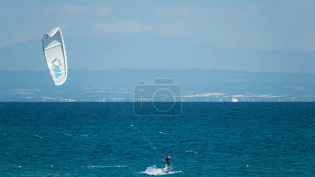 Photo for Gokceada, Canakkale Turkey 08.20.2022 Professional Kite Surfer in action on Waves in Gokceada Kefalos-Aydincik beach. Kitesurf makes slalom on the waves. Imbros Island. - Royalty Free Image