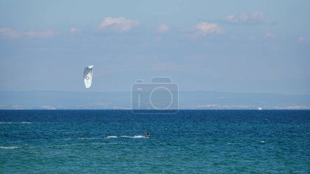 Photo for Gokceada, Canakkale Turkey 08.20.2022 Professional Kite Surfer in action on Waves in Gokceada Kefalos-Aydincik beach. Kitesurf makes slalom on the waves. Imbros Island. - Royalty Free Image