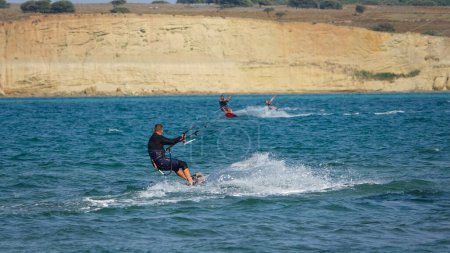 Photo for Gokceada, Canakkale Turkey 08.20.2022 Professional Kite Surfers  in action on Waves in Gokceada Kefalos-Aydincik beach. Kitesurf makes slalom on the waves. Imbros Island. - Royalty Free Image
