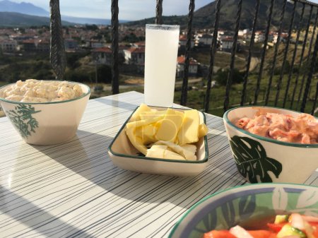 Foto de Aperitivos tradicionales turcos raki y egeo en el plato contra la vista al mar en el balcón en Gokceada, isla de Imbros - Imagen libre de derechos
