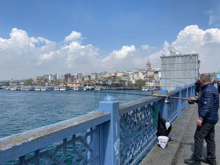 Foto de Pescador en el puente de Galata en Cuerno de Oro, Estambul. Vara de pesca desde el puente de Galata muy popular. - Imagen libre de derechos