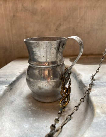 Foto de Cisterna de peltre tradicional encadenada al mostrador de mármol en la iglesia ortodoxa - Imagen libre de derechos