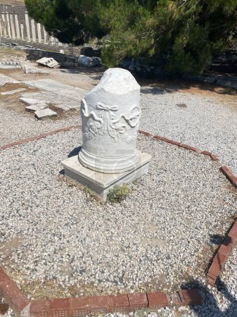 Foto de El templo Asclepion en Pérgamo. Columna de mármol con esculturas de los símbolos del Esclepión - Medicina de serpientes (Eesculapian), ramas de olivo y la rueda de la vida - Imagen libre de derechos