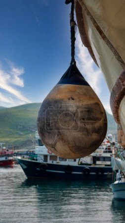 Foto de Guardabarros usados colgados en un viejo barco en el puerto de Kaleky en Gokceada. Vista del muelle Kalekoy con objetos náuticos. Isla de Imbros, Canakkale Turquía - Imagen libre de derechos