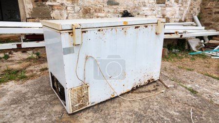 Photo for Old rusty freezer thrown in the garden of a house - Royalty Free Image