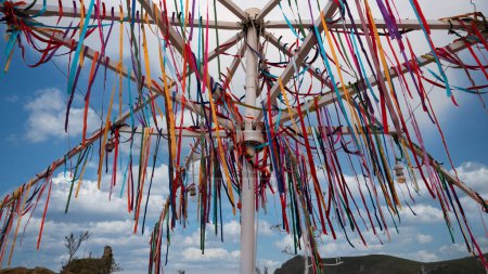 Foto de Coloridas cintas de deseos tradicionales atadas a un poste de hierro en Kalekoy, Gokceada. Muchas cintas multicolores revoloteando en el viento. - Imagen libre de derechos
