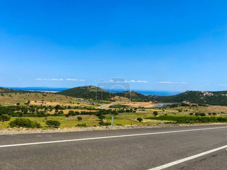 Téléchargez les photos : Route asphaltée avec belle vue sur la nature du centre de Gkeada à la plage Aydnck Kefalos. Île d'Imbros, Anakkale, Turquie - en image libre de droit