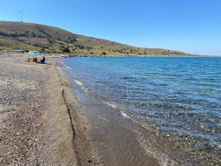 Téléchargez les photos : Gokceada, Canakkale, Turkey June 30, 2023: Guzelce beach, which is very close to Kefalos (Aydincik) beach. Gzelce Bay is also one of the suitable beaches for windsurf and kitesurfing in Gokceada. - en image libre de droit