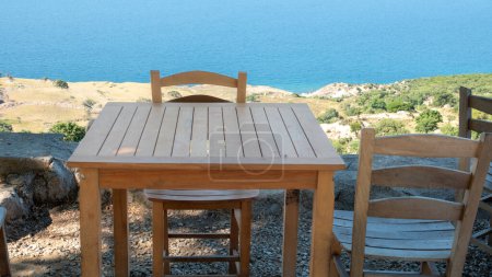 Foto de Gokceada (Imbros) costa y una linda vista al jardín de té pueblo con sillas de madera y mesa. Tepeky pueblo, naralt-Pinarbasi ubicación, Egeo Turquía - Imagen libre de derechos