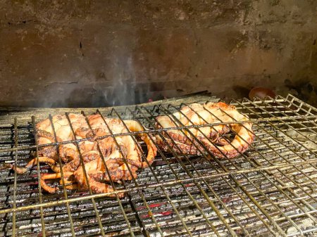 Téléchargez les photos : Les poulpes fraîchement sortis de la mer Égée sont cuits sur le feu du gril. Gokceada, Gokceada, Canakkale, Turquie - en image libre de droit