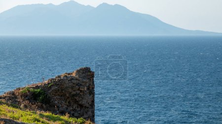 Téléchargez les photos : Gokceada (Imbros) vue sur le littoral avec Samothrace île grecque et ruiné les murs du château de Kalekoy en arrière-plan. Île d'Imbros. Turquie égéenne. Canakkale - en image libre de droit