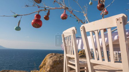 Téléchargez les photos : Lanternes faites de gourdes accrochées sur une branche d'arbre sec, la mer Égée et l'île grecque Samothrace vue dans le restaurant de poisson. Gokceada Canakkale Turquie - en image libre de droit
