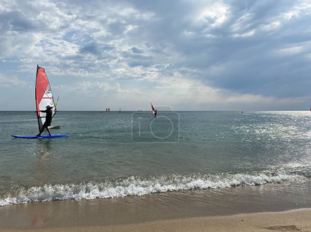 Téléchargez les photos : Gokceada, Canakkale Turquie 9 septembre 2023 ; Surfeurs de vent profitant de la mer Égée et du vent dans la baie de Gokceada Kefalos contre le ciel clair. Île d'Imbros - en image libre de droit