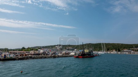 Téléchargez les photos : Sigacik, Izmir, Turquie 10 sept. 2023 Bateaux de pêche au port de plaisance de Teos avec fond de yachts de luxe à Sigacik, Izmir, Turquie. - en image libre de droit