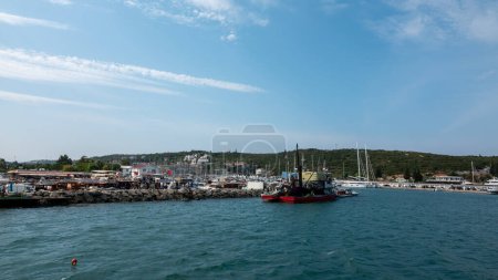 Téléchargez les photos : Sigacik, Izmir, Turquie 10 sept. 2023 Bateaux de pêche au port de plaisance de Teos avec fond de yachts de luxe à Sigacik, Izmir, Turquie. - en image libre de droit