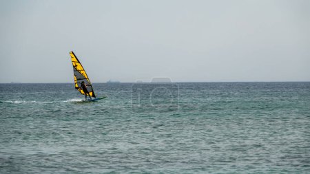Foto de Gokceada, Canakkale Turquía 9 de septiembre de 2023; Surfista de viento disfrutando del mar Egeo y el viento en la bahía de Gokceada Kefalos contra el cielo despejado. Isla de Imbros. - Imagen libre de derechos