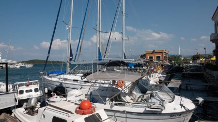 Téléchargez les photos : Urla, Izmir, Turquie 10 sept. 2023 Bateaux de pêche mouillés à la marina du port avec fond de yachts de luxe à Urla, Izmir, Turquie. - en image libre de droit