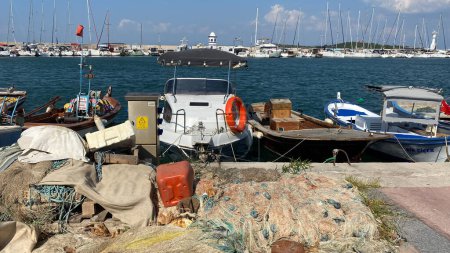 Téléchargez les photos : Urla, Izmir, Turquie 10 sept. 2023 Bateaux de pêche mouillés à la marina du port avec fond de yachts de luxe à Urla, Izmir, Turquie. - en image libre de droit